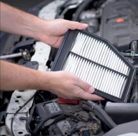 Close-up of a mechanic holding a clean auto air filter