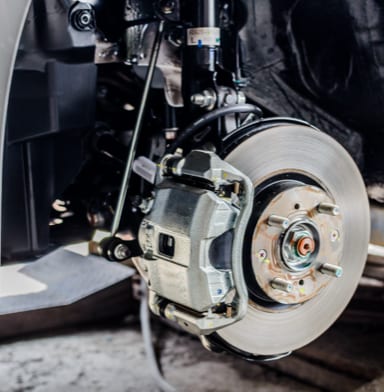 Close-up of a parked vehicle's brakes in a garage