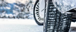 Close-up of a car's winter tires outside turning in the snow